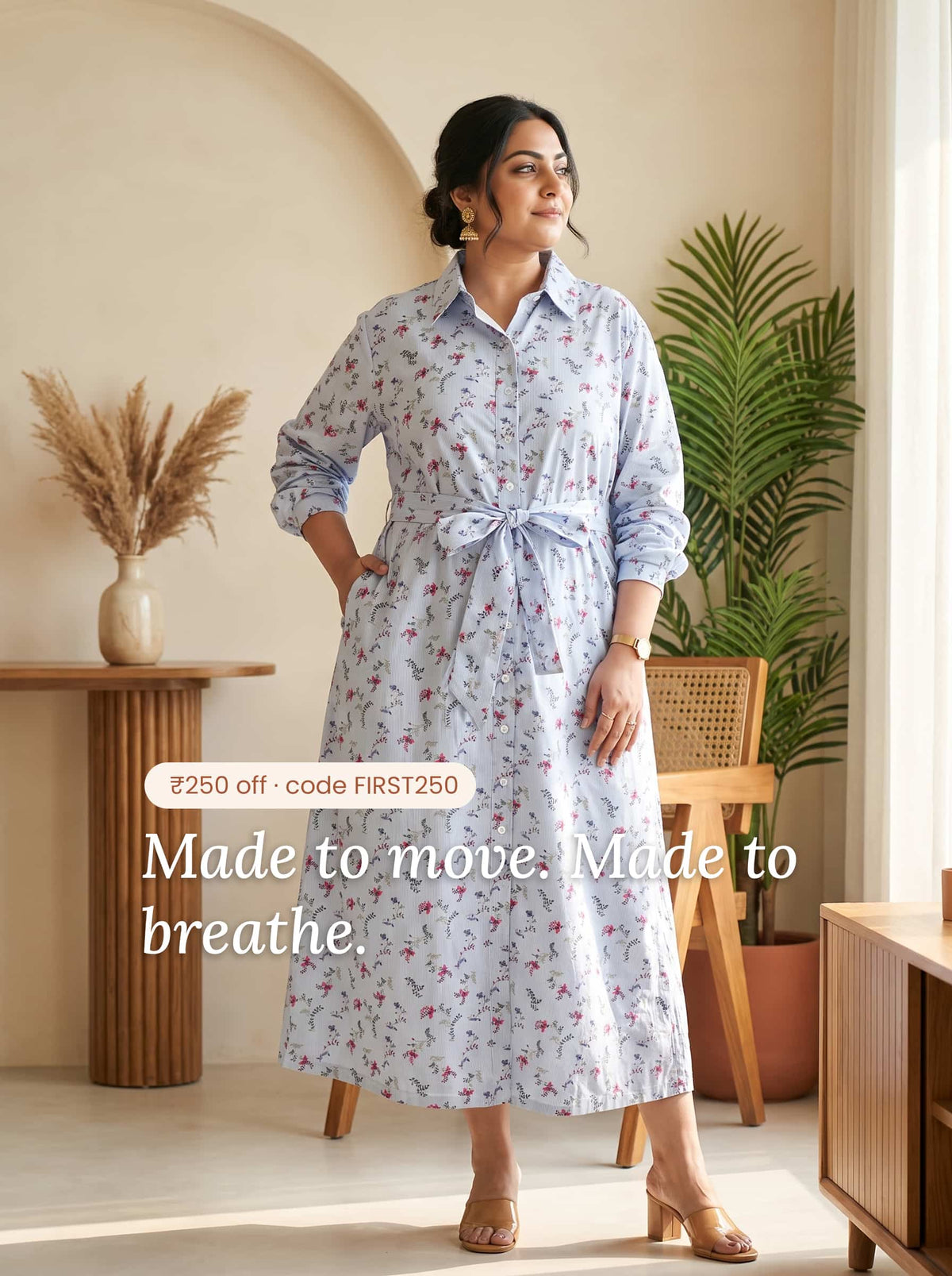 Woman wearing a light blue floral midi dress with a tie waist and buttons.
